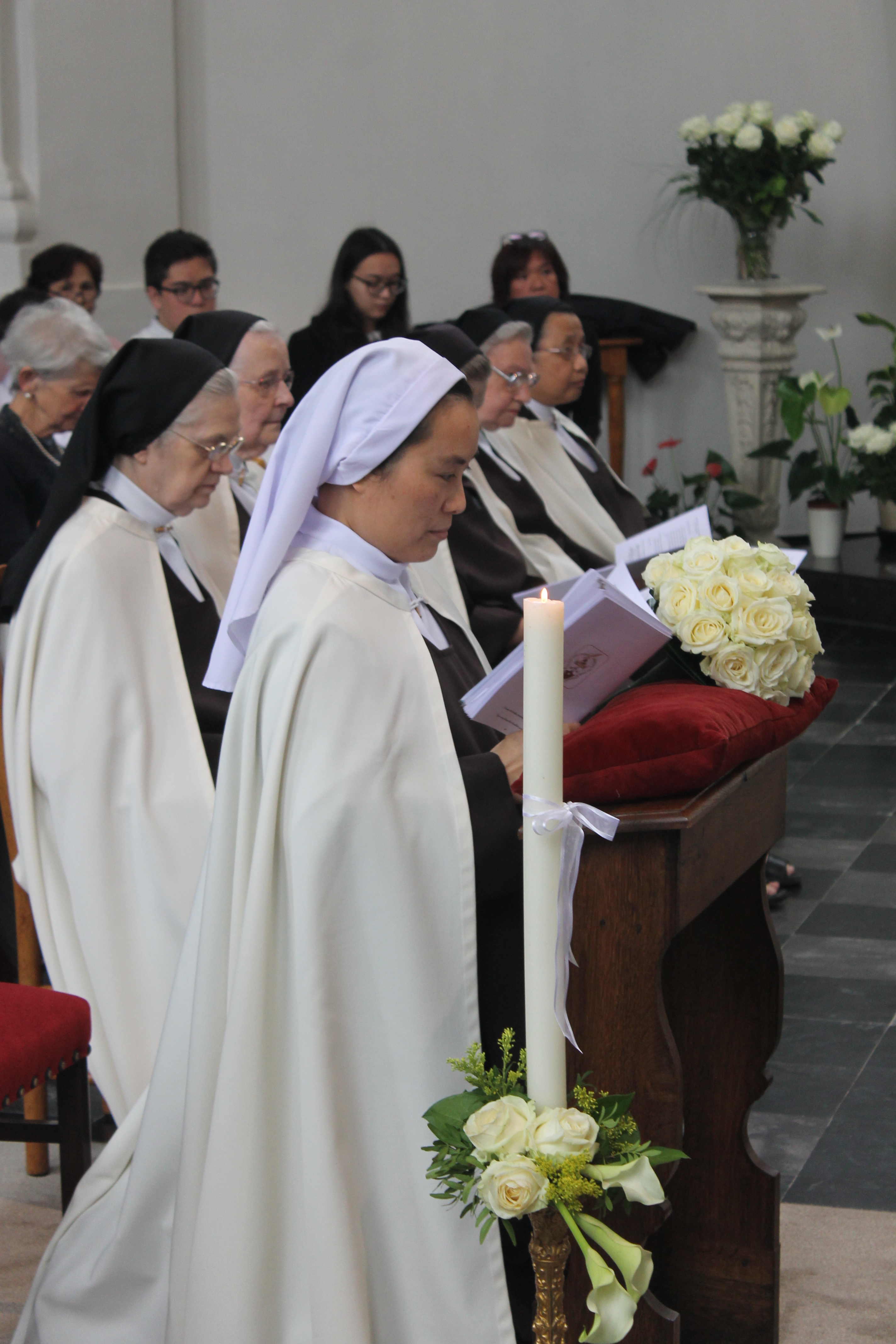 Zuster Marie Paul Thérèse bij het begin van de viering. Als een bruid neemt ze plaats op de bidbank vooraan in de basiliek.