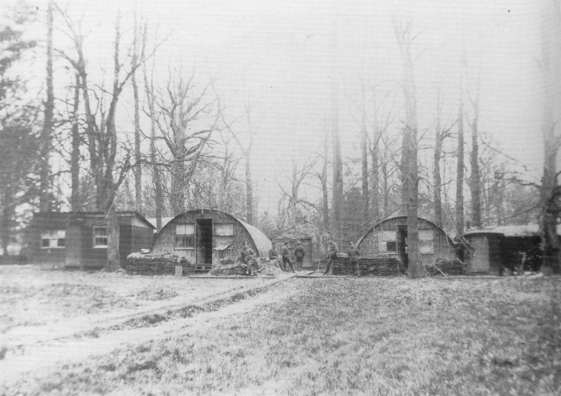 In het bos rond het kloostergebouw worden tunnelvormige barakken opgetrokken voor de soldaten.