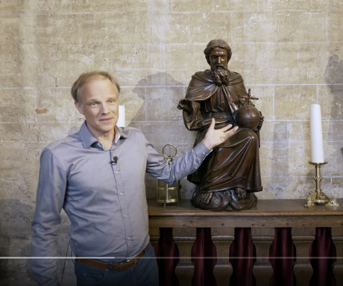 Hans Geybels toont een antieke houten sculptuur die God de Vader voorstelt in de Sint-Leonarduskerk in Zoutleeuw.