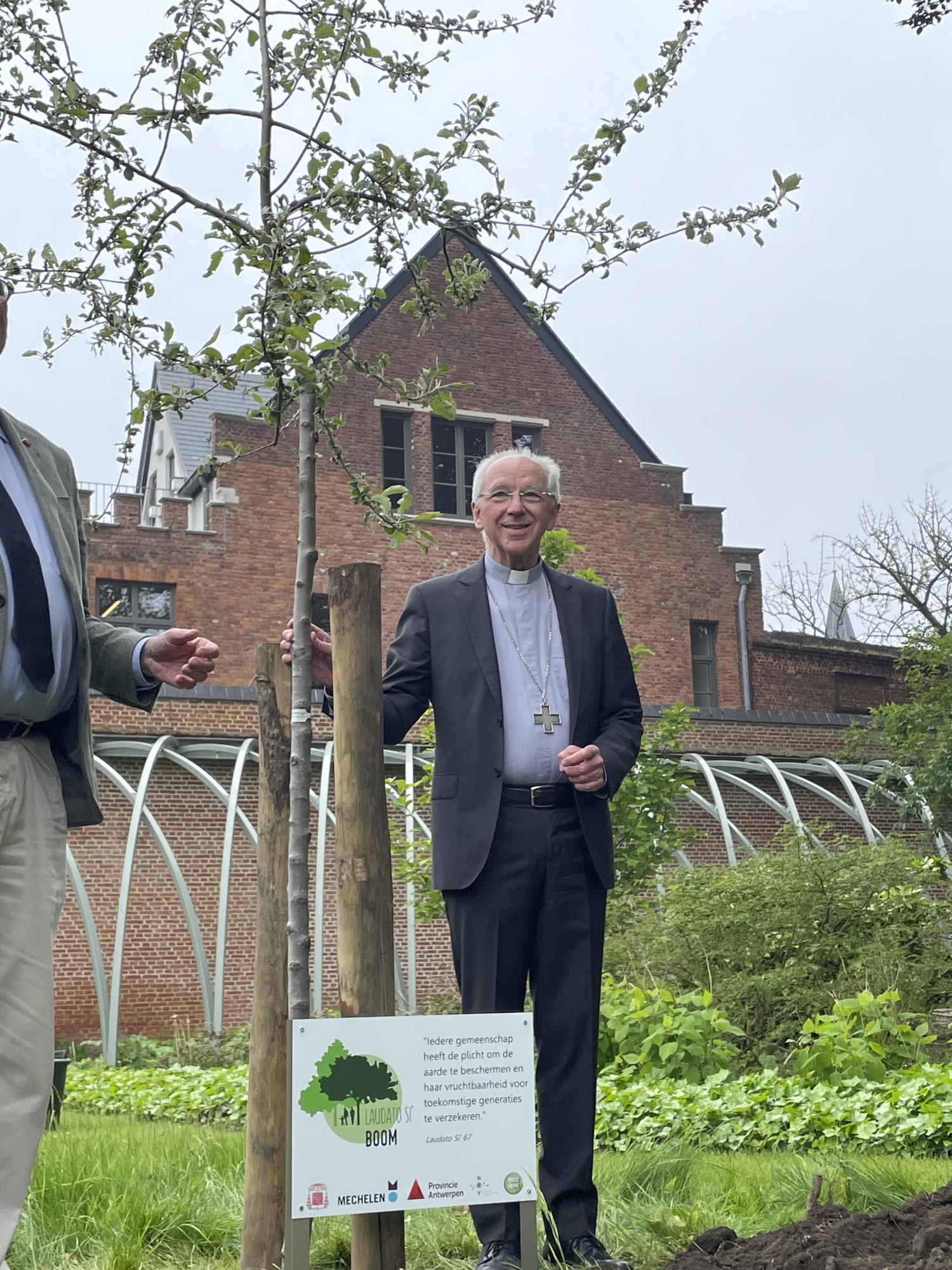 Kardinaal De Kesel plant een appelaar in de tuin van het aartsbisschoppelijk paleis in Mechelen.