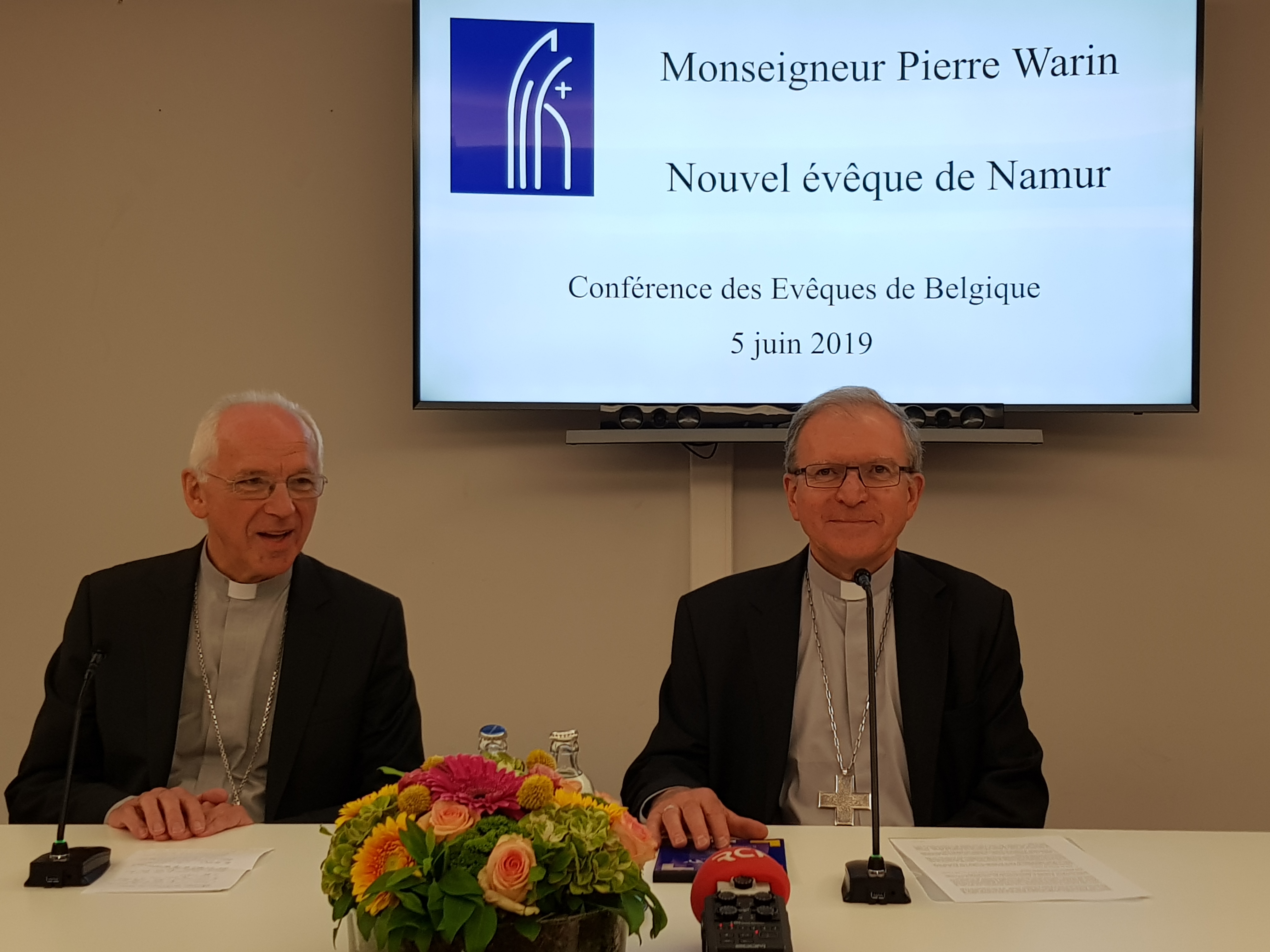 Kardinaal Jozef De Kesel en bisschop Pierre Warin op de persconferentie in het Interdiocesaan Centrum in Brussel