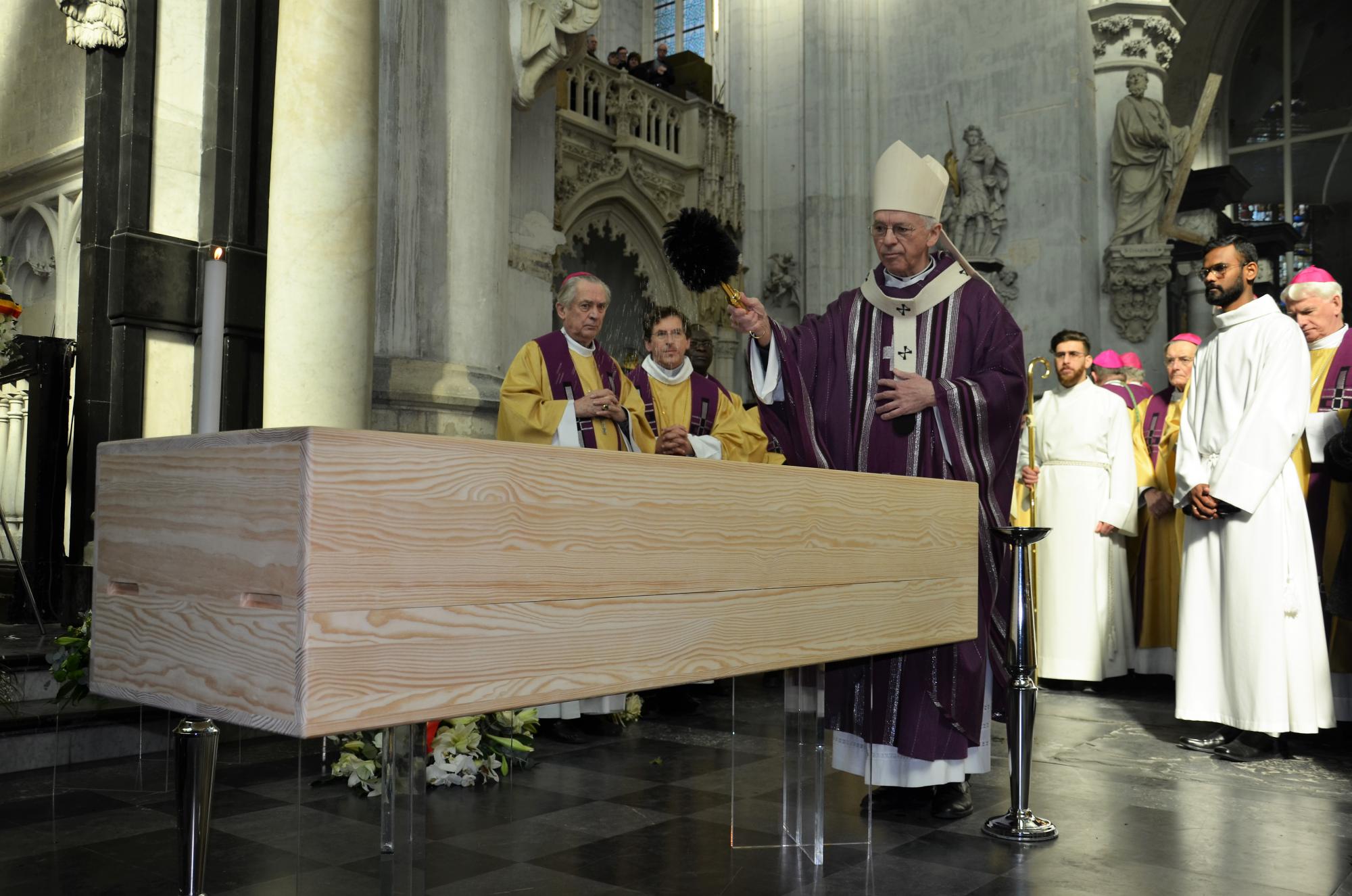 Kardinaal De Kesel besprenkelt de kist ten afscheid. 'Wij vertrouwen Godfried aan uw vaderlijke liefde in wie hij zijn vertrouwen stelde. Wij zijn U dankbaar voor al het goede dat Gij ons door hem gaf en waardoor hij blijvend teken is van uw Liefde.'