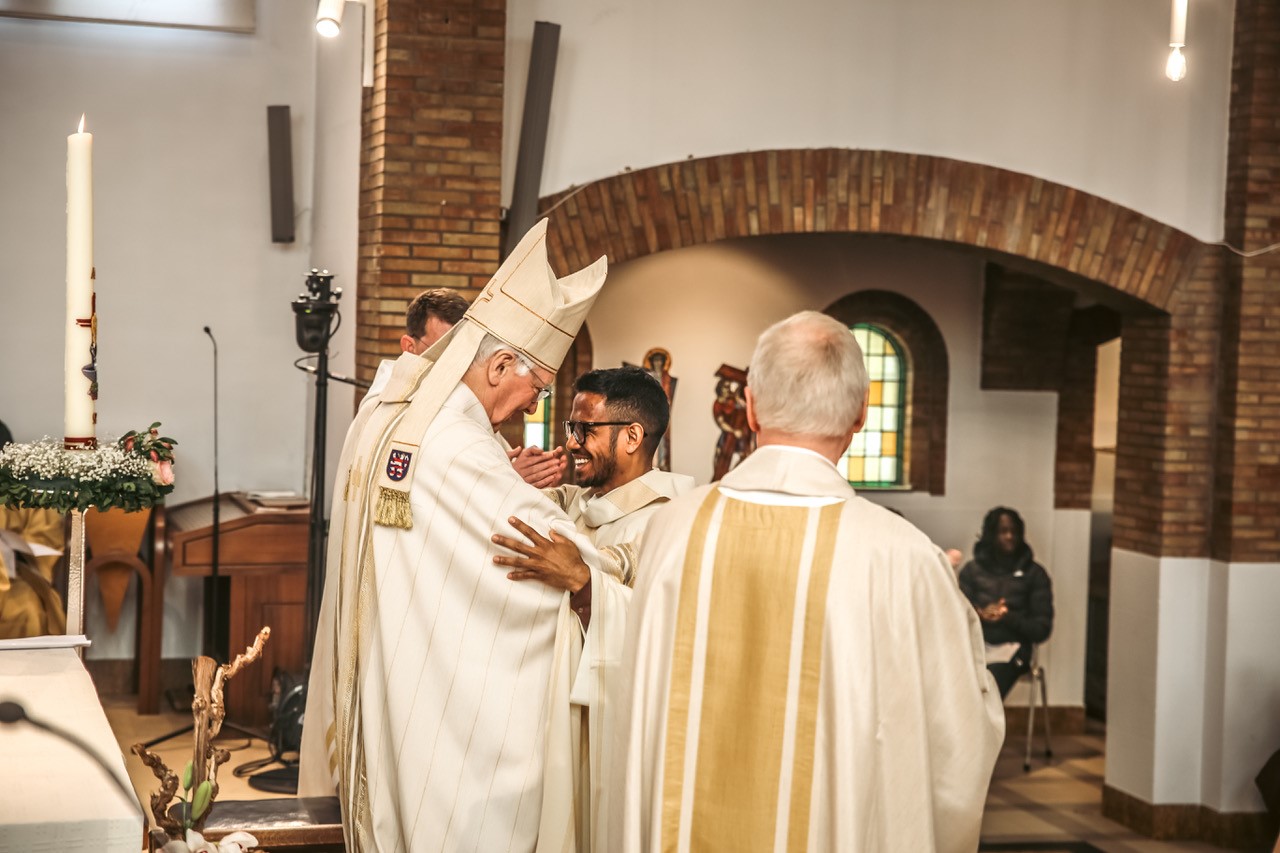 Bisschop Luc Van Looy, zelf salesiaan, feliciteert de wijdeling Cirilo De Deus 