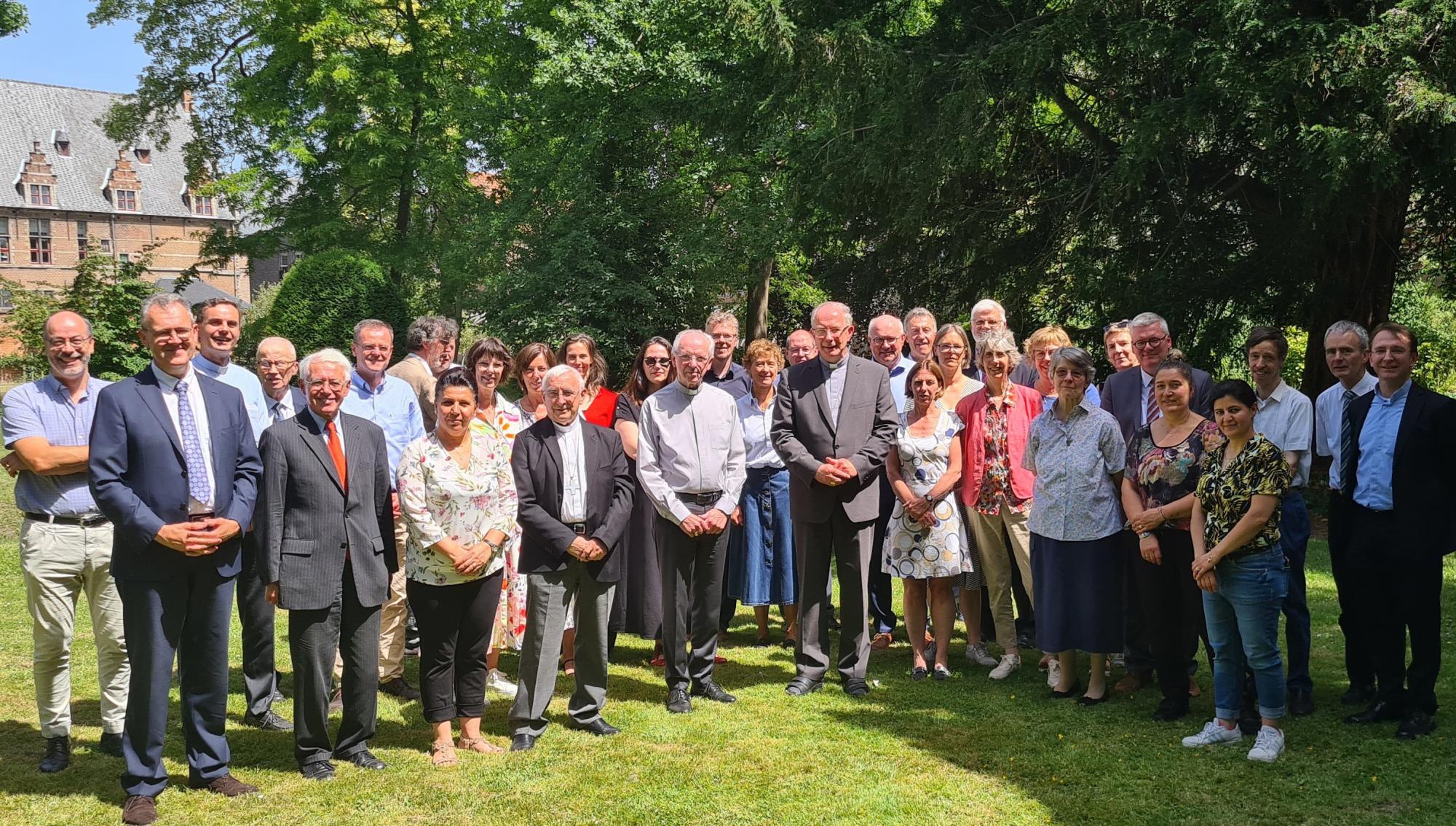 De jarige kardinaal Jozef De Kesel met de leden van de bisschopsraad en het personeel van het aartsbisdom in de tuin van het bisschopshuis in Mechelen