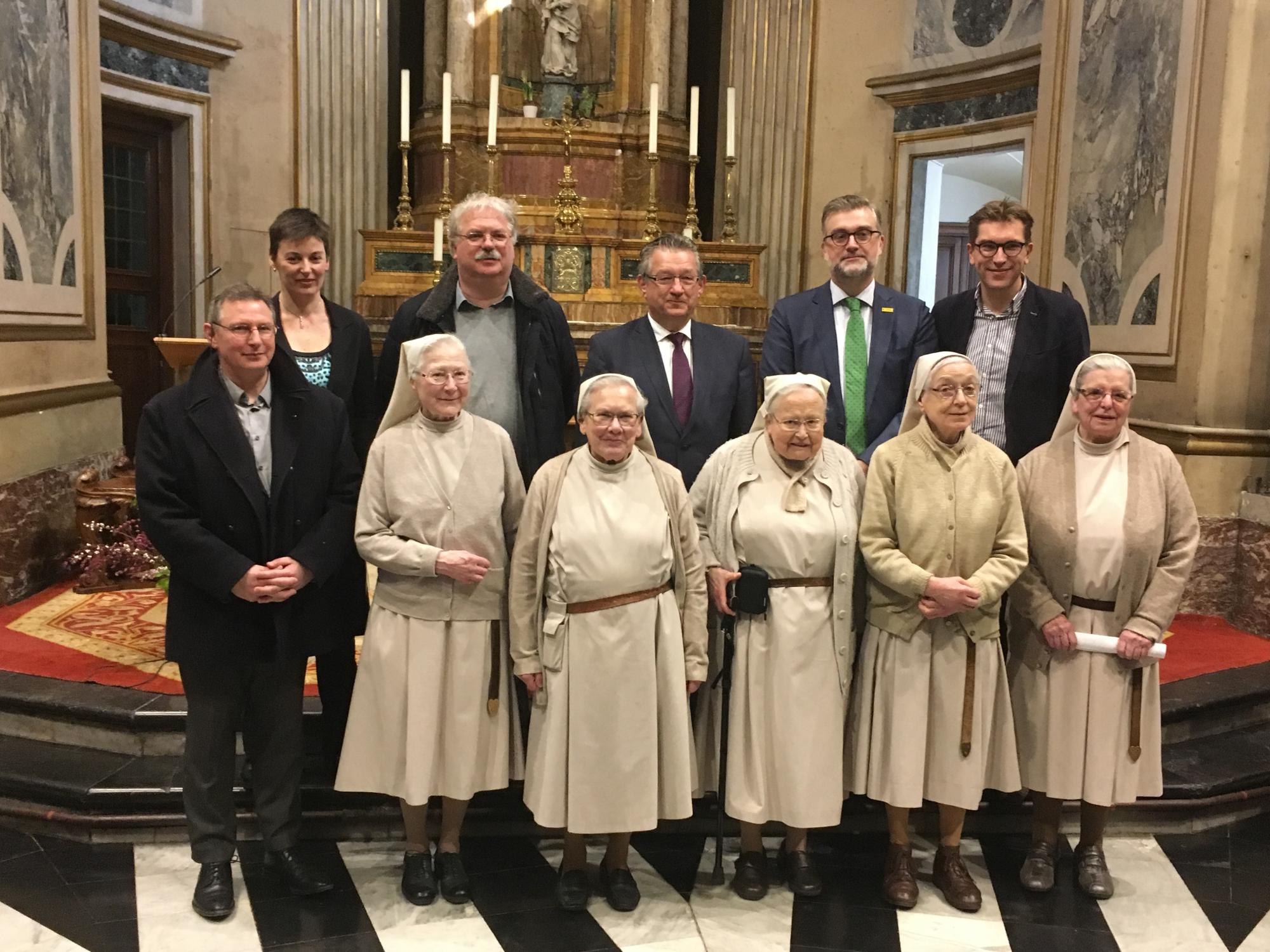 Prior Martin, zusters van het Engels Klooster met rechts zuster Aline; achteraan v.l.n.r. Doenja Van Belleghem (coördinator), Nico Blontrock (schepen), Dirk De fauw (burgemeester), Peter De Wilde (Toerisme Vlaanderen) en Franky Demon (schepen)