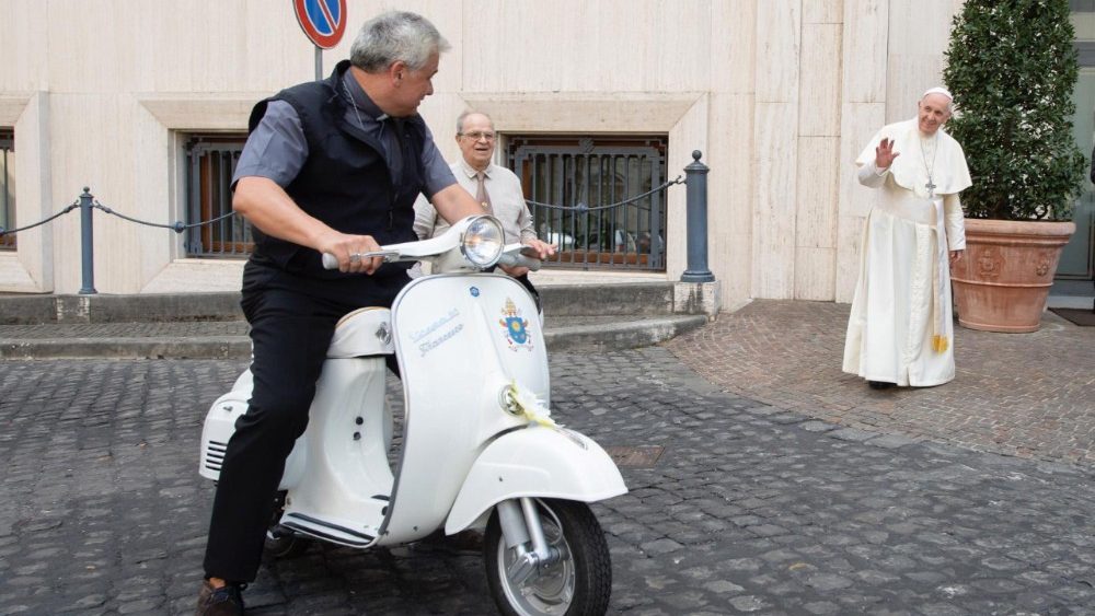 Konrad Krajewski, de armenaalmoezenier van de paus, probeert even de vespa uit 