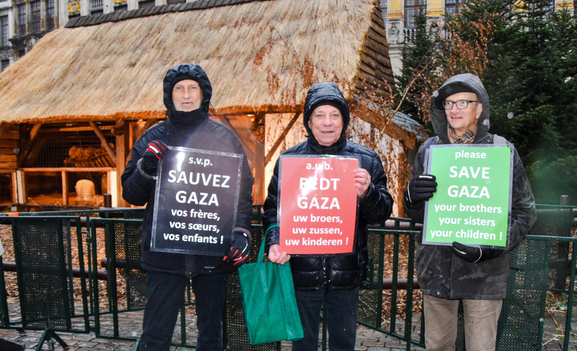 Jef Vlaminckx, Dries van Ootegem en Jo Hanssens van de werkgroep vredesspiritualiteit van Pax Christi Vlaanderen trotseren de ijzige regen met een boodschap van solidariteit voor Gaza.