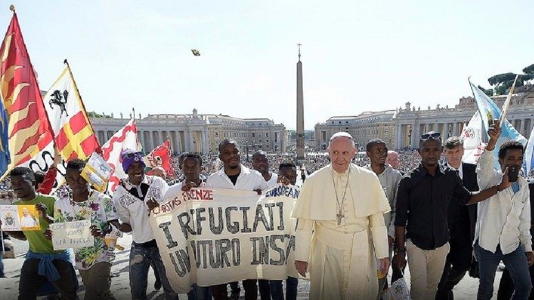 Paus Franciscus omringd door enkele vluchtelingen